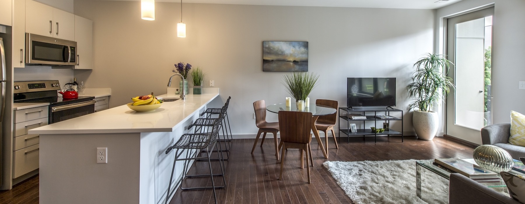 a living room with a tv, tables and chairs