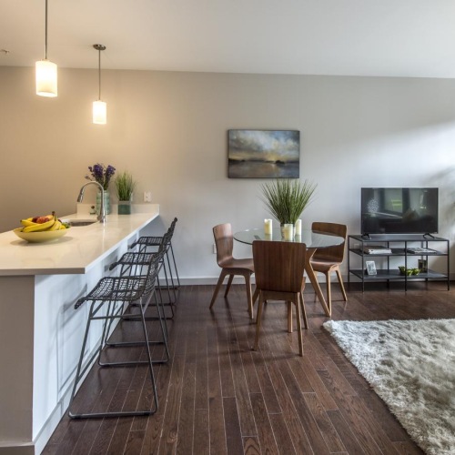 a living room with a tv, tables and chairs