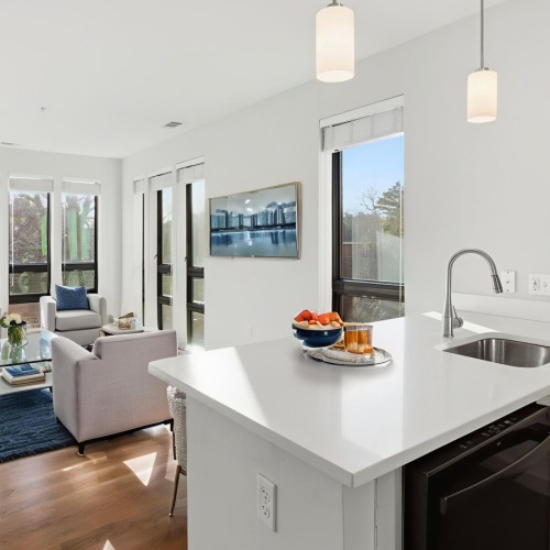 a kitchen and a living room with a couch and chairs